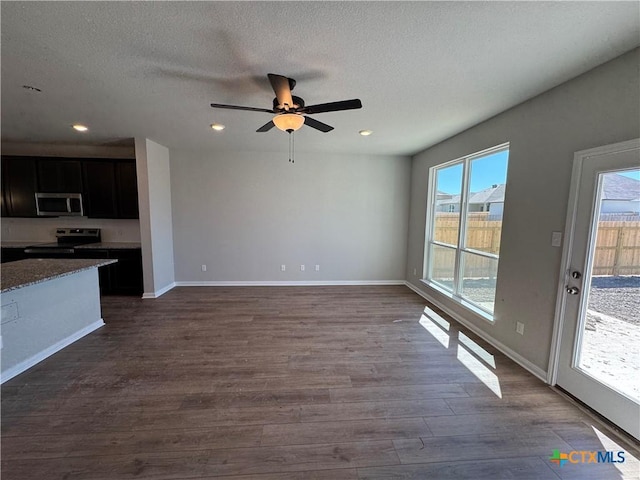 unfurnished living room featuring ceiling fan, dark hardwood / wood-style floors, and a textured ceiling