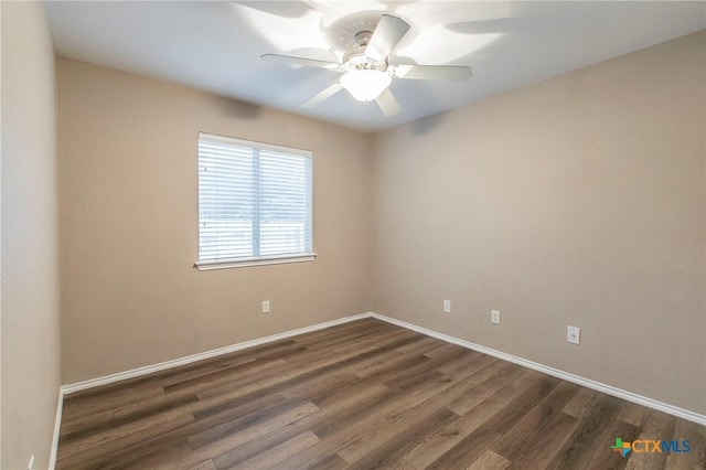 empty room featuring baseboards, ceiling fan, and dark wood-type flooring