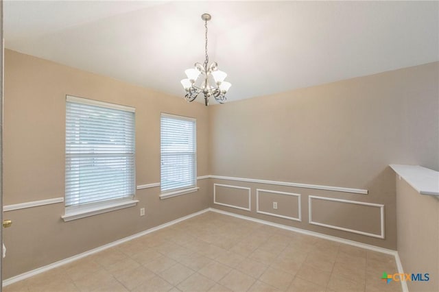 spare room with a notable chandelier