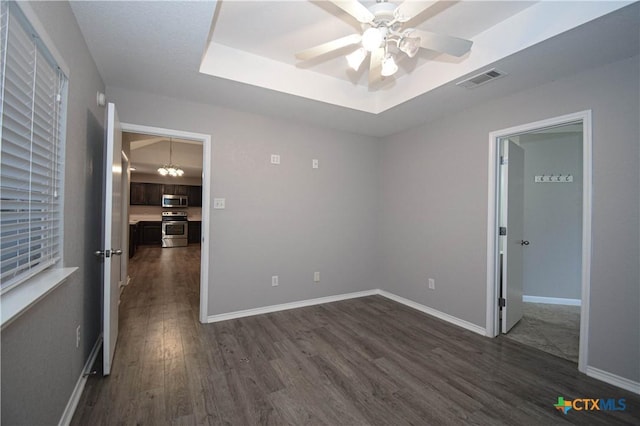 1614 Twisted Oak Dr, Temple, TX 76502 - unfurnished room featuring dark wood finished floors, a ceiling fan, baseboards, and a tray ceiling