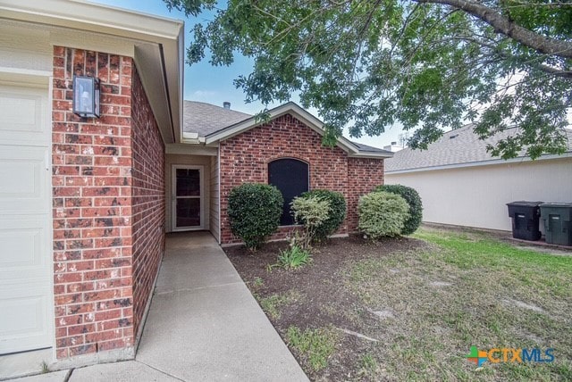 1614 Twisted Oak Dr, Temple, TX 76502 - entrance to property with brick siding, an attached garage, and roof with shingles