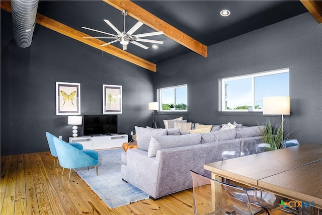 living room with vaulted ceiling with beams, ceiling fan, and light hardwood / wood-style floors