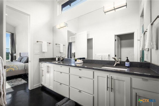 bathroom with concrete flooring, a high ceiling, and vanity