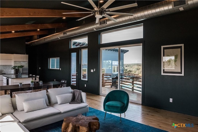 living room featuring beamed ceiling, high vaulted ceiling, and hardwood / wood-style flooring