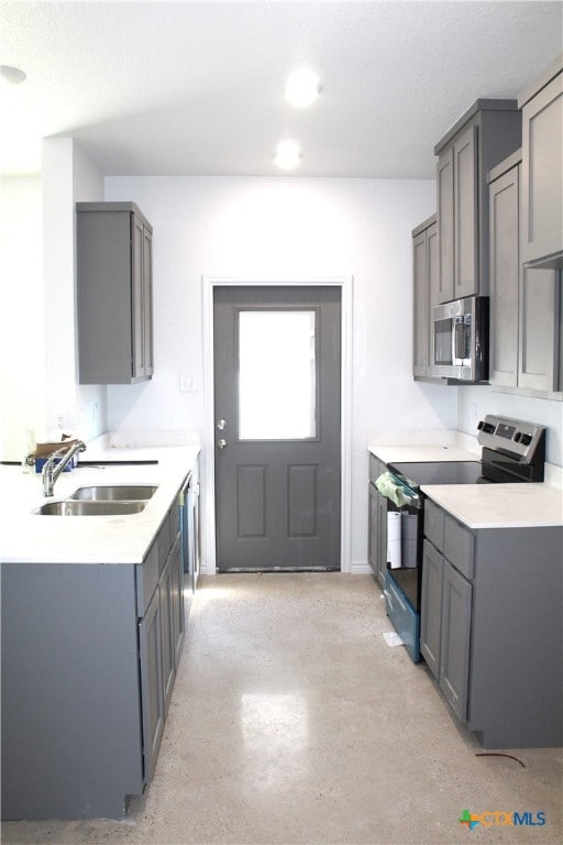 kitchen with appliances with stainless steel finishes, sink, and gray cabinetry