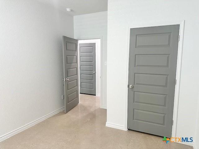 interior space featuring finished concrete floors and baseboards