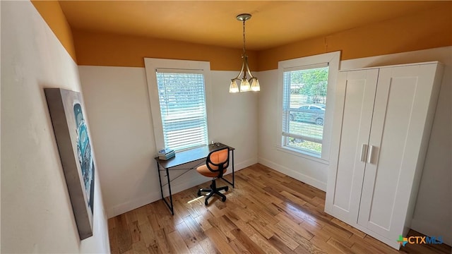 office space featuring a notable chandelier, baseboards, and wood finished floors