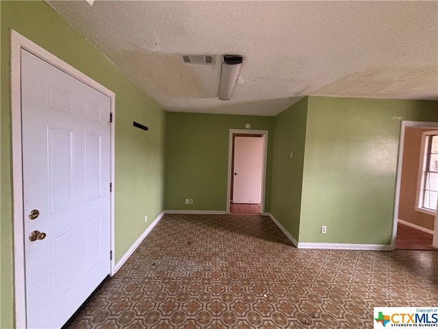 unfurnished room featuring a textured ceiling