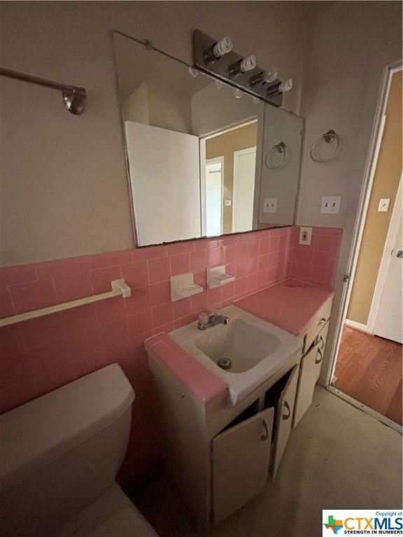 bathroom with toilet, sink, and hardwood / wood-style flooring