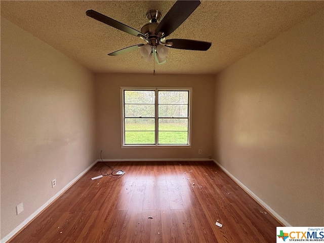 spare room featuring wood-type flooring, ceiling fan, and a textured ceiling