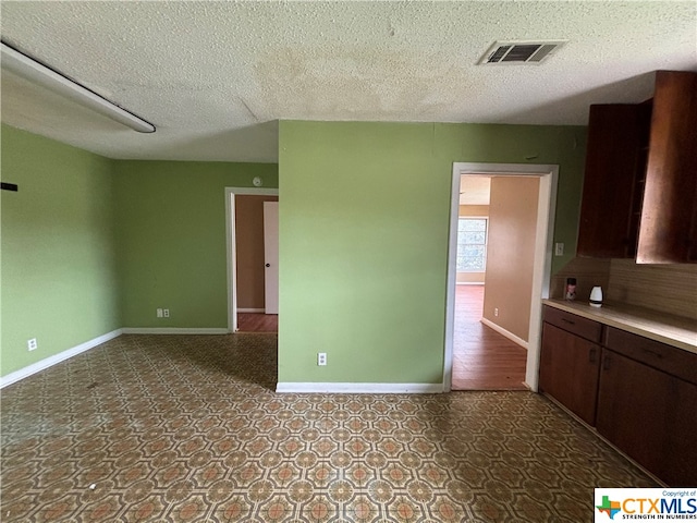 unfurnished room with a textured ceiling