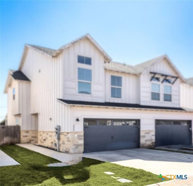 view of property featuring a garage and a front yard