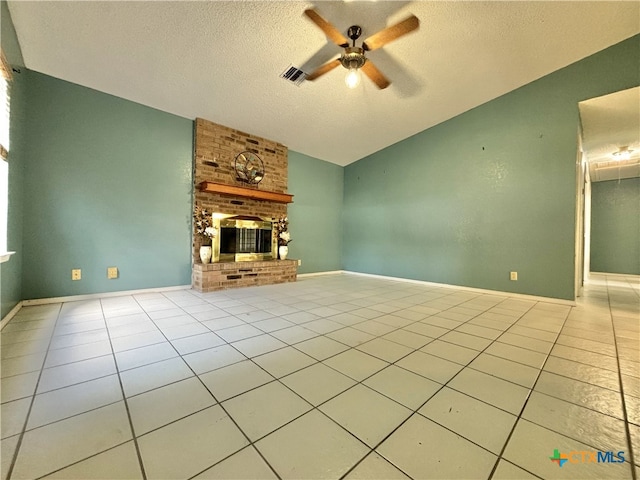 unfurnished living room with a brick fireplace, lofted ceiling, a textured ceiling, light tile patterned floors, and ceiling fan