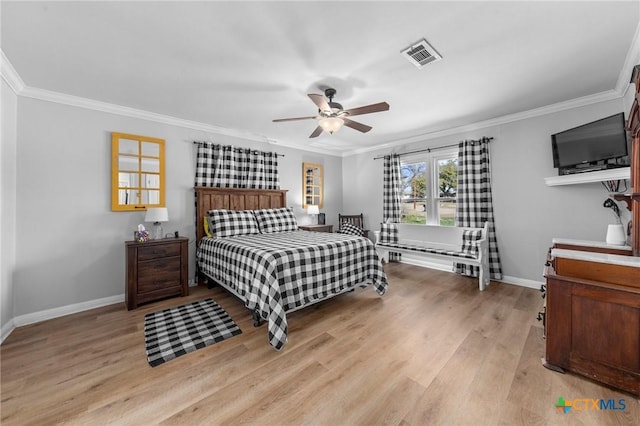 bedroom featuring light wood-type flooring, visible vents, crown molding, and baseboards