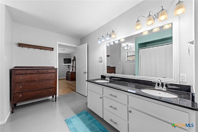 full bathroom with double vanity, curtained shower, concrete floors, and a sink