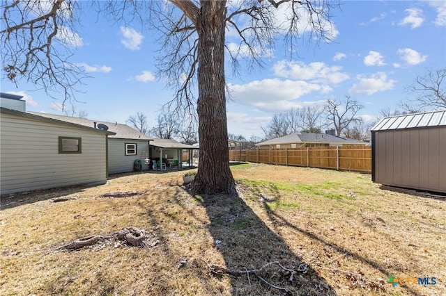 view of yard featuring a shed, an outdoor structure, and a fenced backyard