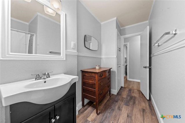 full bathroom with crown molding, baseboards, wood finished floors, and vanity