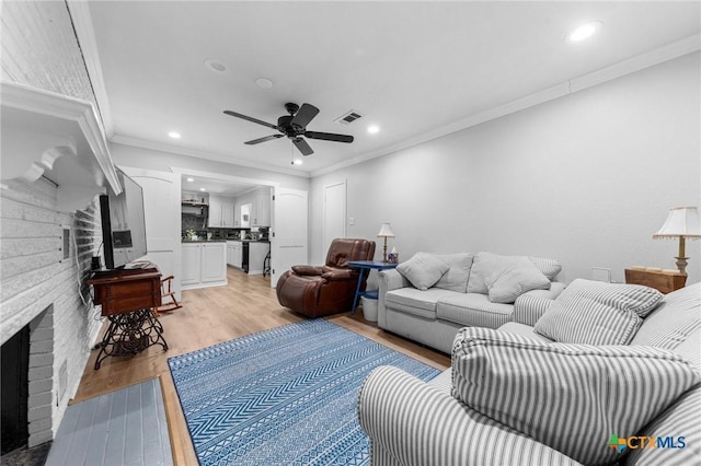 living area featuring visible vents, a ceiling fan, light wood-type flooring, a fireplace, and recessed lighting