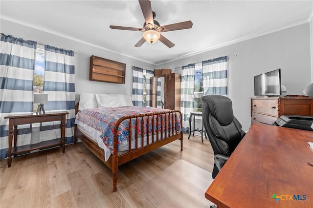 bedroom with light wood-style floors, multiple windows, and ornamental molding