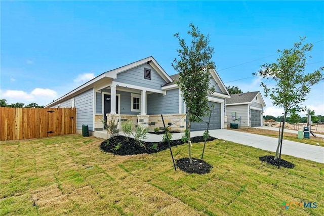 view of front of property featuring a porch, a garage, and a front lawn