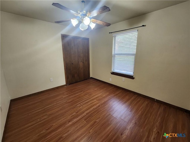 interior space featuring a closet, ceiling fan, and dark wood-type flooring