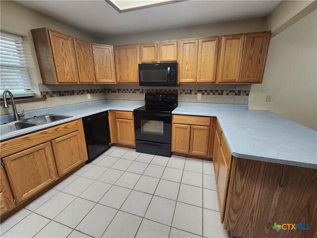 kitchen with light tile patterned floors, sink, backsplash, and black appliances