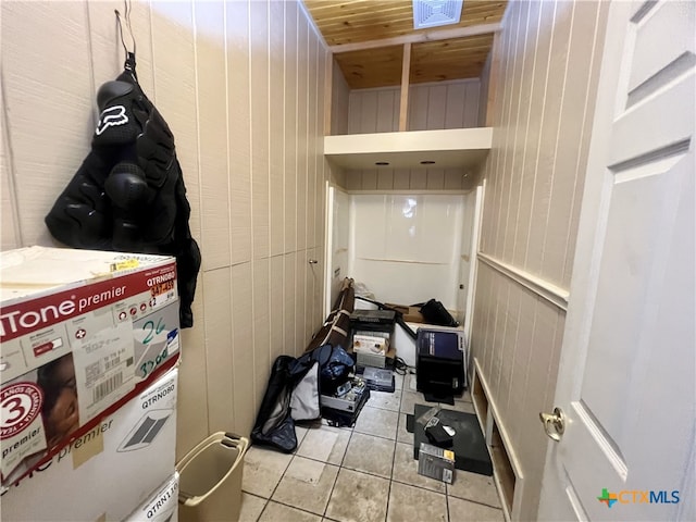 laundry area featuring wooden walls, wood ceiling, and light tile patterned floors