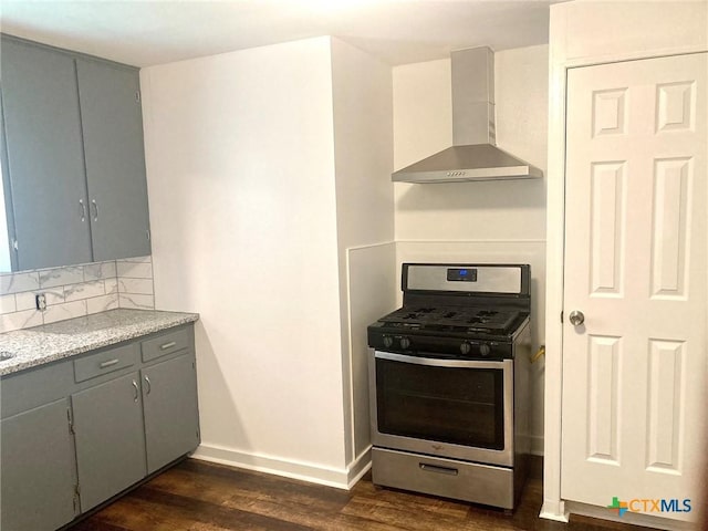 708 E Loma Vista Ave, Victoria, TX 77901 - kitchen with stainless steel gas stove, wall chimney exhaust hood, gray cabinets, dark wood-style flooring, and decorative backsplash