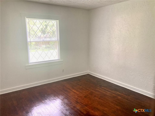 708 E Loma Vista Ave, Victoria, TX 77901 - unfurnished room featuring dark wood-style flooring, a textured wall, and a textured ceiling