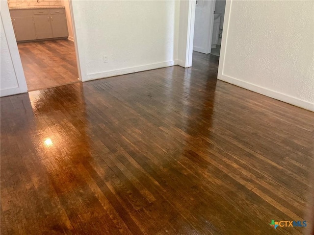 708 E Loma Vista Ave, Victoria, TX 77901 - unfurnished room with dark wood-style floors and a textured wall