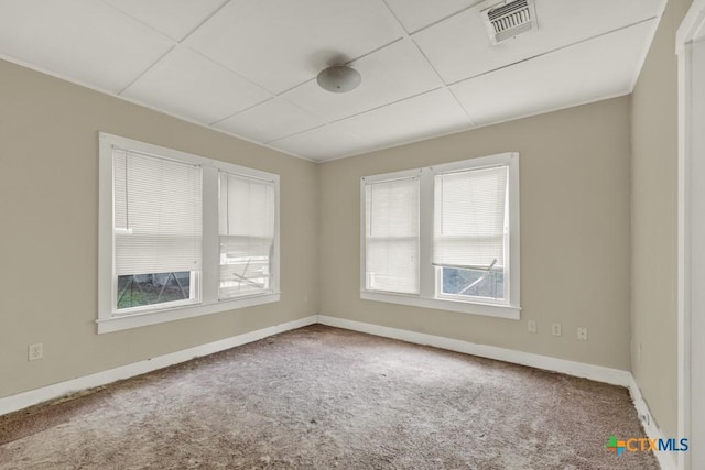 carpeted spare room featuring a paneled ceiling