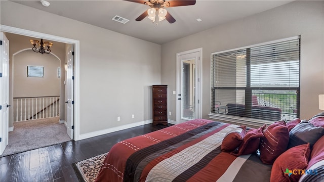 bedroom featuring dark wood-type flooring and ceiling fan with notable chandelier