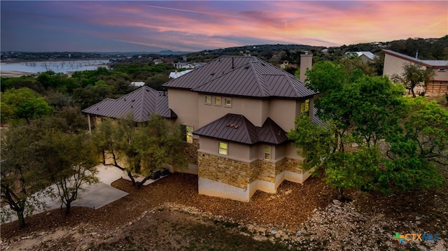 aerial view at dusk featuring a water view