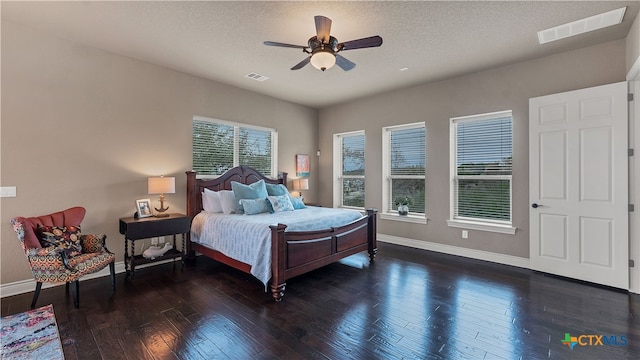 bedroom featuring ceiling fan, dark hardwood / wood-style floors, and a textured ceiling