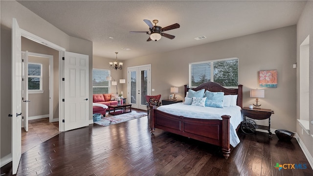 bedroom featuring french doors, ceiling fan with notable chandelier, dark hardwood / wood-style flooring, and a textured ceiling