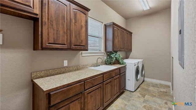 laundry room featuring cabinets, sink, washing machine and clothes dryer, and a textured ceiling