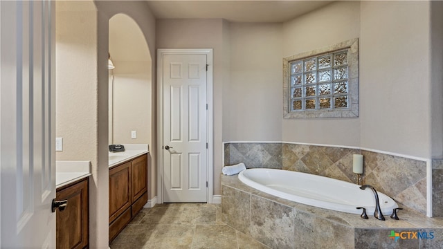 bathroom with tiled bath and vanity