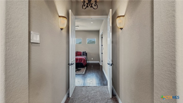 hallway with dark wood-type flooring and a textured ceiling