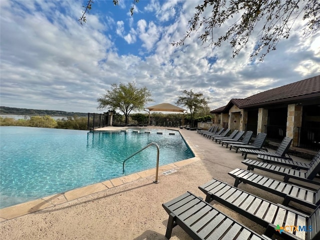 view of pool featuring a water view and a patio area