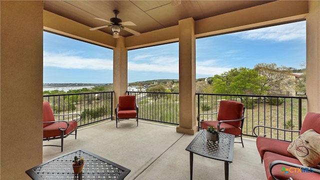 view of patio / terrace featuring a water view, ceiling fan, and a balcony