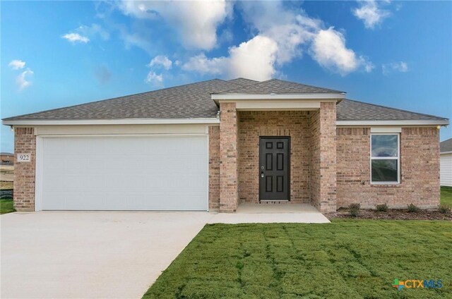 single story home featuring a front lawn and a garage