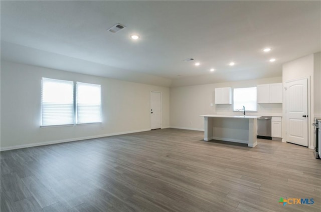 unfurnished living room with sink and light wood-type flooring