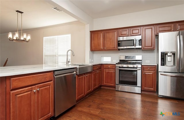 kitchen with sink, dark hardwood / wood-style floors, a chandelier, decorative backsplash, and appliances with stainless steel finishes