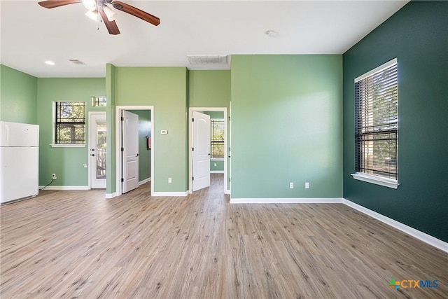 180 Jim Bowie Dr, Paige, TX 78659 - unfurnished living room with wood finished floors, ceiling fan, and baseboards