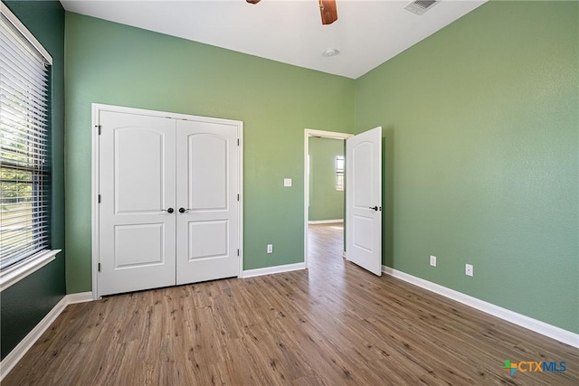 180 Jim Bowie Dr, Paige, TX 78659 - unfurnished bedroom with wood finished floors, baseboards, a closet, and ceiling fan