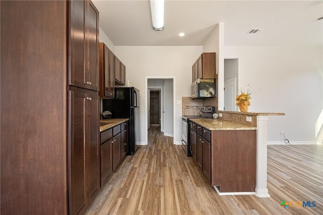 180 Jim Bowie Dr, Paige, TX 78659 - kitchen featuring appliances with stainless steel finishes, light wood-style flooring, a peninsula, and baseboards