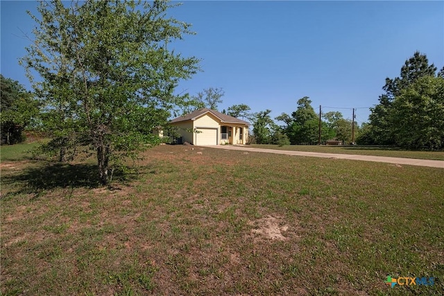 180 Jim Bowie Dr, Paige, TX 78659 - view of green lawn with a garage and driveway