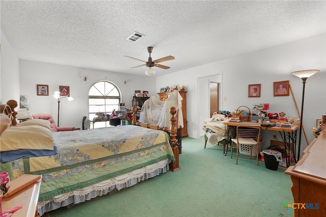 bedroom featuring a ceiling fan, visible vents, carpet floors, and a textured ceiling
