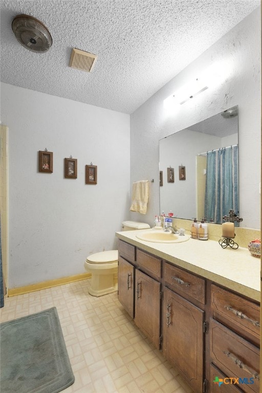 full bathroom featuring tile patterned floors, toilet, vanity, a shower with curtain, and a textured ceiling