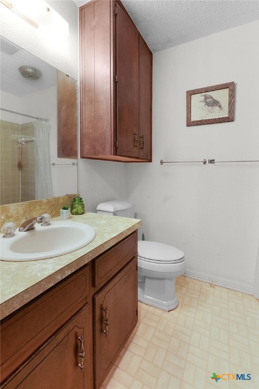 full bath featuring curtained shower, a textured ceiling, toilet, and vanity